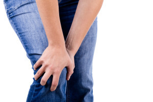 Woman with knee pain on white background